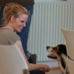 Antje Nöhren, die Geschäftsleiterin des Kultursekretariats NRW Gütersloh, und ein Hund lächeln sich an.