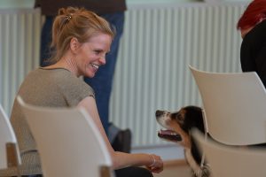 Antje Nöhren, die Geschäftsleiterin des Kultursekretariats NRW Gütersloh, und ein Hund lächeln sich an.